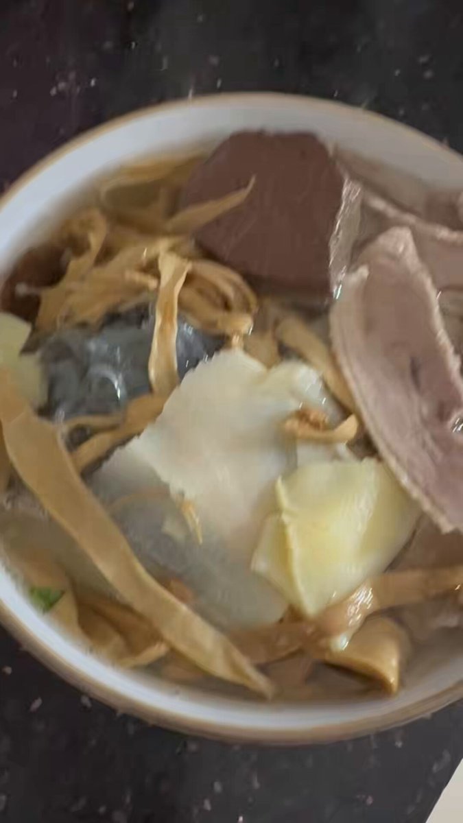 The image shows a bowl of food sitting on top of a table. The bowl contains noodles, meat, and vegetables such as carrots and broccoli. There are also some pieces of plastic wrap around the food items. The text "GM GM CT Get up and eat breakfast, bros!!!! @wallchain @quipnetwork". This message is likely meant to encourage people to eat their meals or at least start their day with a healthy meal.