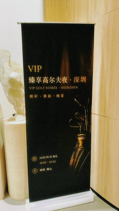 A black pull-up banner advertises a 'VIP 臻享高尔夫夜·深圳 / VIP GOLF SOIRÉE · SHENZHEN' event on 2026.08.30 from 16:00 - 20:00 in 深圳·南山, featuring the words '挥杆·雅叙·晚宴' and an image of golf clubs, displayed next to a small statue.
