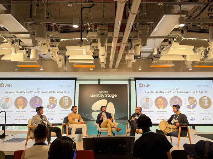 A panel of six speakers sits on the "Agentic Identity Stage" at the Ai4 conference, discussing the "Agentic Identity and Trust Framework for AI Agents," with company logos from Aledade, Next, Visa, Stripe, and Vercel displayed on screens flanking the stage.