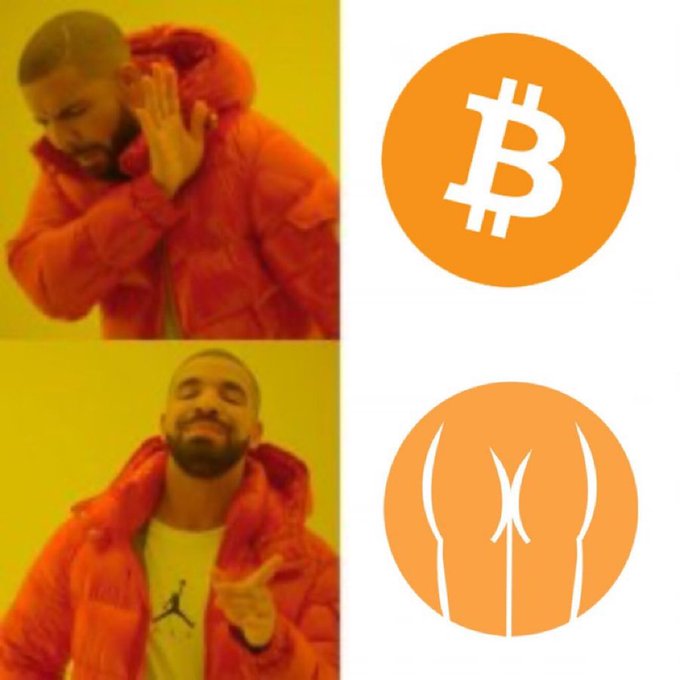 The image shows a man wearing an orange jacket, with his hand raised up, pointing at two different logos - one of which is a Bitcoin symbol, while the other is a butt icon. The man appears to be making a funny face or gesture towards these two logos, possibly indicating that he has a strong opinion about them.