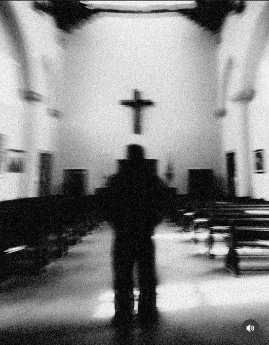 A grainy black-and-white photo shows a silhouetted figure standing with arms outstretched in the aisle of a church, facing a large cross on the wall. The image evokes a moment of surrender or supplication, aligning with the post's reflective message about striving to "get it right."