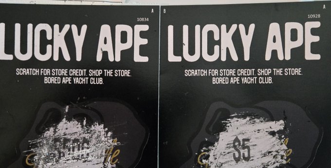 Two "LUCKY APE" scratch-off cards from Bored Ape Yacht Club are shown side by side, with the left card revealing a $500 store credit and the right card showing $5, illustrating the user's excitement about winning the larger prize.