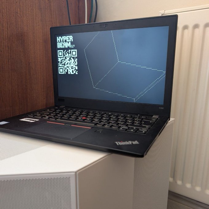 The image shows an open laptop computer sitting on a white stand or baseplate. The screen of the laptop displays a message that says "Boot from USB to run a laptop with HyperBEAM as the OS", indicating that the user might be using a bootable USB drive to install a specific operating system, such as Ubuntu. This is likely an attempt to bypass the limitations imposed by the current OS on the computer. The image also contains a QR code and a text box containing information about the booting process.