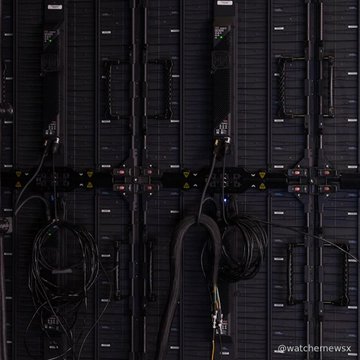 A dark photograph of server racks with tangled cables, watermarked 'watchmemesx'.
