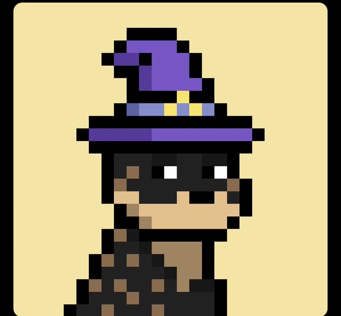 A pixel art profile picture of a stylized character wearing a purple witch hat with a black mask covering their eyes against a pale yellow background.