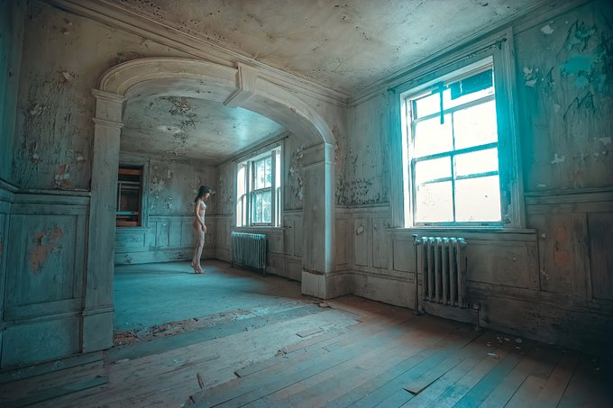 A nude figure stands in the doorway of a decaying, teal-toned room within an abandoned asylum, surrounded by peeling walls, weathered wooden floors, and large windows with old radiators. The haunting, atmospheric setting reinforces the somber, introspective tone suggested by the title "My Daddy Was A Dollar."