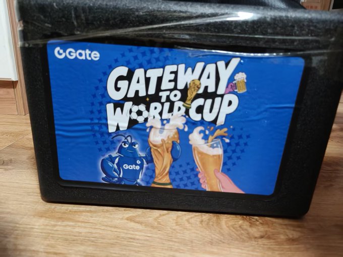 A black display stand features a blue promotional sign reading 'Gate GATEWAY to WORLD CUP' with cartoon characters and illustrations of beer glasses.