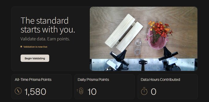 A dashboard displaying "The standard starts with you. Validate data. Earn points" with "Begin Validating" button, showing 1,580 All-Time Prisma Points, 10 Daily Prisma Points, and 0 Data Hours Contributed, alongside an overhead view of a desk with a vase of flowers, papers, glasses, and equipment. The image relates to the post by showing the Prismax points dashboard, illustrating the user's accumulated Prisma Points despite the project's ambiguous stance on whether these points will translate to an airdrop reward.