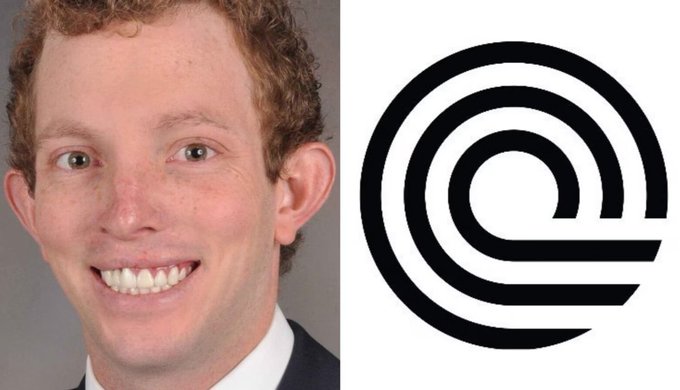 The image features a man with curly hair wearing a suit, smiling at the camera. The background of the photo shows an image of the company logo, which consists of a circle with a line through it. The text "ONDO" can be seen in the image as well.