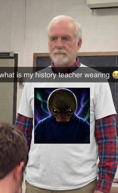 A photo of an older man with a pixelated face wearing a white t-shirt featuring an alien graphic, with overlaid text reading 'what is my history teacher wearing 😭'.