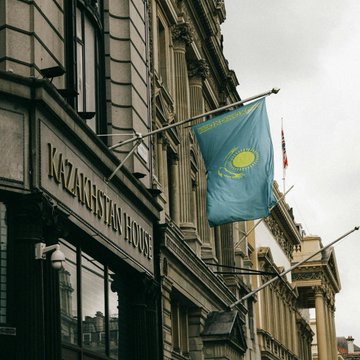 The image shows the exterior of "KAZAKHSTAN HOUSE" with a Kazakhstan flag hanging prominently from the building. The image relates to the post by visually representing Kazakhstan, the country that has approved new rules for strategic digital mining allowing large miners discounted electricity in exchange for contributing crypto to a state-backed reserve.