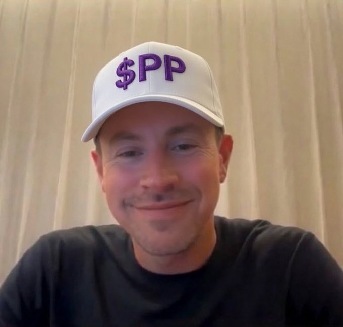 A man wearing a white baseball cap with "$PP" embroidered in purple smiles at the camera, visually matching the post's reference to the $PP ticker and its weekly MACD indicator.