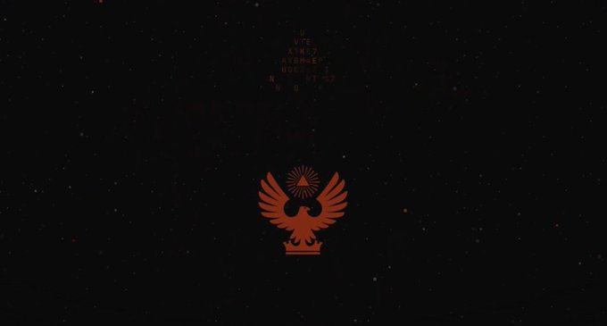 A dark screen displaying a red, stylized bird or eagle emblem with spread wings in the center, along with faint, small text above it.