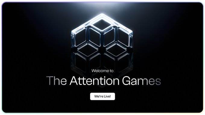 A dark screen displaying a glowing metallic cube logo with the text 'Welcome to The Attention Games' and a button reading 'We're Live!'.
