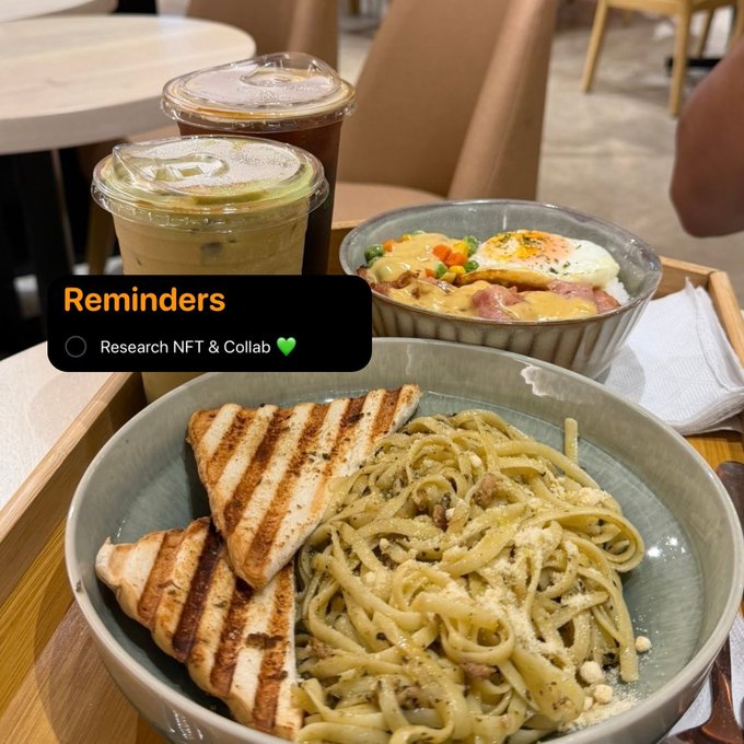 A flat-lay of a café meal featuring a pasta bowl with grilled chicken, a breakfast bowl with eggs, and iced lattes, overlaid with a Reminders app notification reading "Research NFT & Collab 💚" — visually linking the post's call for collaboration power from OGs to a casual brainstorming moment over food.