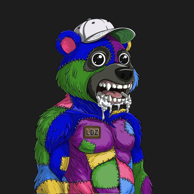 The image features a cartoon bear wearing a colorful outfit that includes patches of different colors such as blue, green, purple, pink, yellow, orange, and white. The bear has a white hat on its head and appears to be wearing a patchwork costume with various colors. The caption for the image reads "Good morning CT pandas have been cooking Check out this @LunardollzNft collab trait, exclusive to panda and LP doll or lunar ape holders for free Comes packed with a nice little staking bonus too".