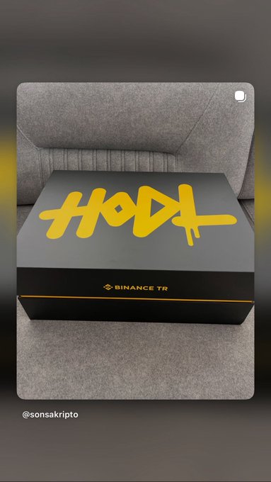 A black box with yellow stylized text 'HODL' and 'BINANCE TR' logo sits on a gray textured surface, with the handle '@sonsakripto' visible at the bottom.