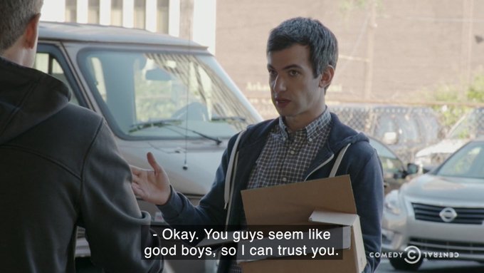 A scene from a Comedy Central show featuring a man holding a cardboard box talking to another person, with subtitles reading: 'Okay. You guys seem like good boys, so I can trust you.'