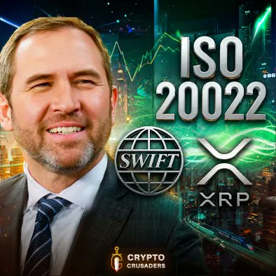 The image features a man wearing a suit, smiling for the camera while standing next to a city skyline at night. The background of the image includes a large globe with the words "ISO 20022" written above it. In the foreground, there is an advertisement for Bitcoin and Ripple, which are cryptocurrencies that have been gaining popularity in recent years. The man's suit and the nighttime setting suggest that he might be attending or participating in an event related to cryptocurrency or financial markets.
