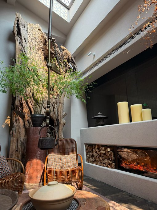 A cozy interior featuring a rustic wooden tree trunk, wicker chairs, and a lit fireplace with stacked firewood beside tall candles.

The image shows a tranquil lounge setting that visually represents the comfort and security of having idle USDC funds continuously earning yield on TermMax, rather than sitting unused.