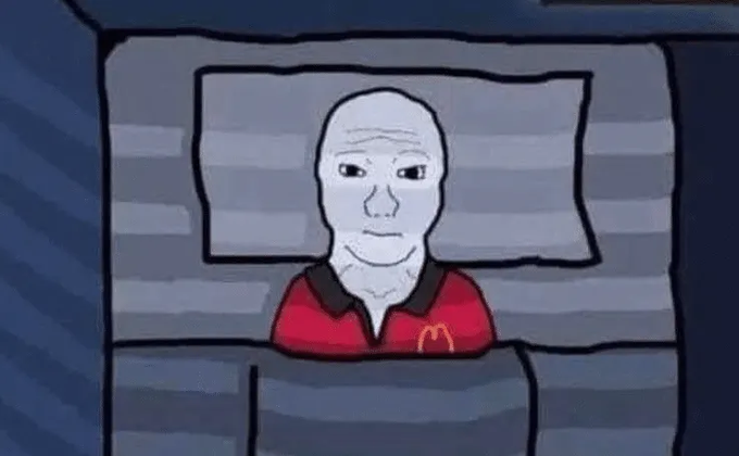 A simple cartoon drawing depicting a bald, pale figure lying in bed wearing a red McDonald's uniform shirt, reminiscent of Wojak-style art.