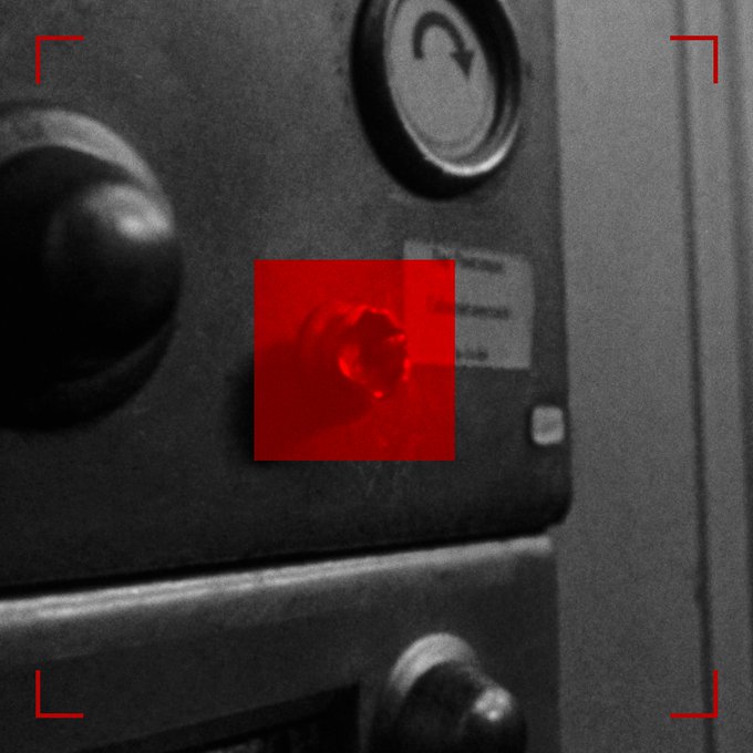 A black and white photograph of an industrial control panel with knobs and a power button, featuring a red square overlay highlighting a specific component.