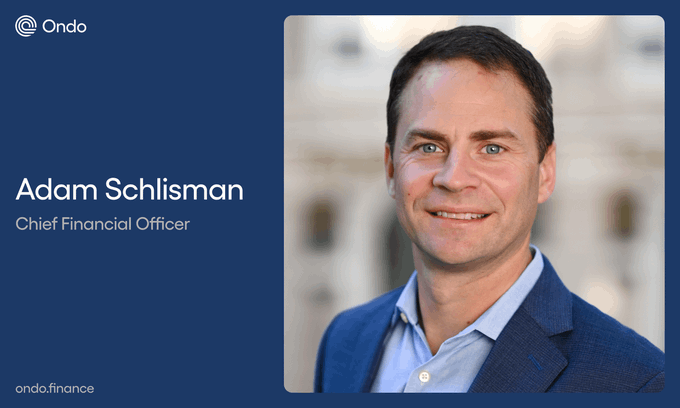 A professional headshot graphic on a navy blue background introduces Adam Schlisman, Chief Financial Officer at Ondo (ondo.finance), featuring a smiling man in a blue blazer against a blurred architectural backdrop. The image visually celebrates his appointment, aligning with the post's announcement of him joining the Ondo leadership team.