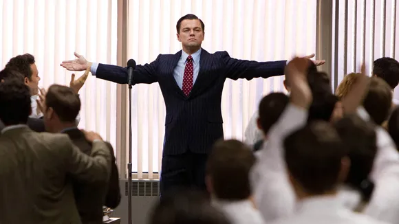 Leonardo DiCaprio as Jordan Belfort addresses a crowd, mirroring the excitement of the recent 1,110 peak viewership for a stream about the $BTC bull market.