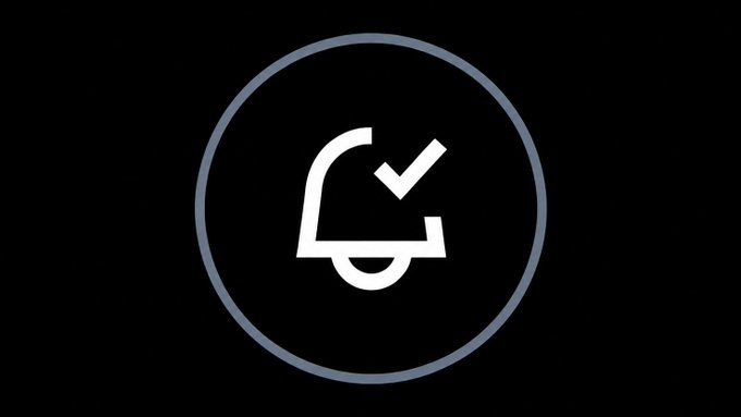A simple white notification bell icon with a checkmark inside a circle is displayed on a black background.