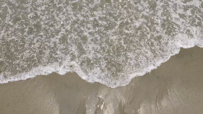 The image shows a photo of ocean waves crashing onto the shore, covering a large portion of its surface. In the background, there's text that reads "Good morning legend' @perx_trade offers decentralized perpetual futures trading". The primary focus of the photo is on the beach and the water, capturing the beauty and power of nature.