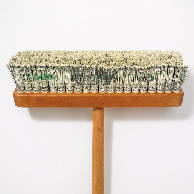 **Art Installation**: An art piece by an artist named 'Green (Gord)' features a wooden broom-like brush with bristles made from rolled US dollar bills, mounted on a wooden T-shaped stand against a white background.
