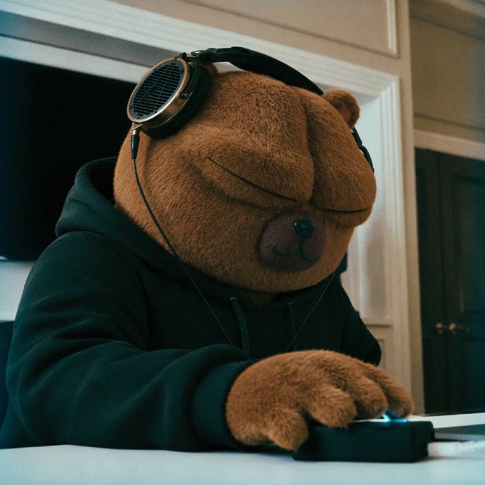A bear in a hoodie wearing headphones while listening to music (or checking charts) — humorously symbolizing bearish feelings and music to one's ears about the "$BOBO" ticker on the rise.