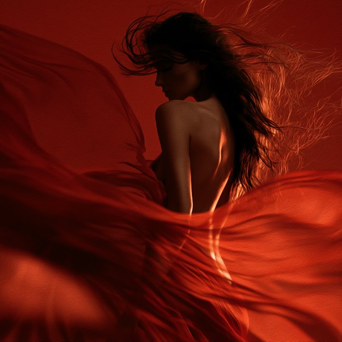 An artistic, stylized photo of a woman with flowing dark hair surrounded by dramatic red fabric against a deep red background.