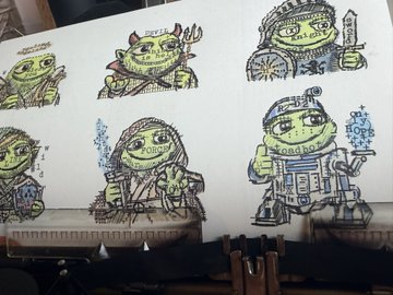 A wall displaying colorful illustrations of green frog-like characters dressed as Star Wars characters, including Yoda and what appears to be Darth Vader and other Star Wars figures.