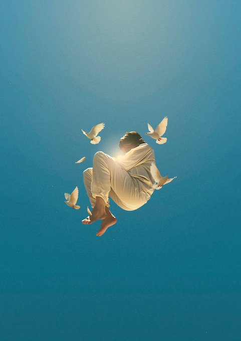 The image features a person wearing white clothing, lying down with their legs crossed, surrounded by numerous birds flying around them. The scene takes place against a blue sky background, creating an atmosphere of freedom and tranquility. The person appears to be floating in mid-air or falling asleep, while the birds seem to be enjoying the moment as well. This image captures the essence of a dreamy, surreal experience where the boundaries between reality and imagination blur.