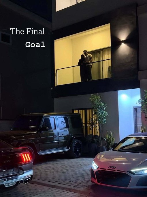The image features a couple standing outside of their house next to two cars, one white and one black. The text "The Final Goal" appears above them, which could be related to the content of the post or simply an interesting caption for the photo.