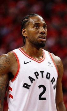 Kawhi Leonard, wearing his Toronto Raptors #2 jersey, looks on during a game as news breaks that he has avoided contract void and suspension, with an 87% chance of playing for the Raptors this season.