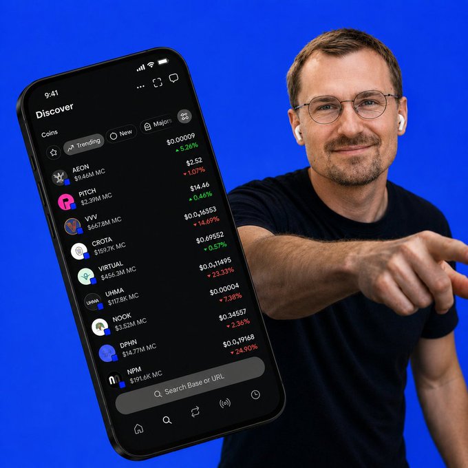 The image features a man wearing glasses and pointing at his cell phone screen that displays information about cryptocurrency trading platforms. One of these platforms is called gBase, which seems to be growing rapidly with new projects launching every week. The man appears to be interested in this platform or has some knowledge about it.