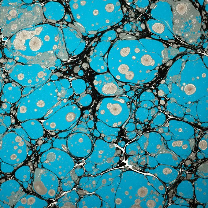 The image features a blue background with black dots, creating an abstract art style that resembles a watercolor painting or a marble effect. The dots are scattered throughout the image, giving it a sense of depth and texture. The colors used for this artwork are predominantly blue and black, which adds to its unique visual appeal.