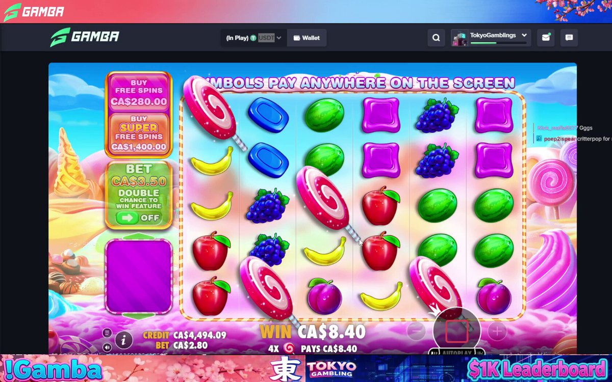 The image displays a large screen with a video game featuring various candies, including lollipops, gummy bears, and other sweets, along with fruit-themed game elements such as bananas and apples. The game appears to be sponsored by Gamora, which is indicated in the top left corner of the image.

A gaming website's banner ad for a massive candy giveaway promotion is shown at the bottom right side of the screen. This ad is likely responsible for attracting many players who try the game during the contest. Players can win prizes by playing the game and reaching specific goals or milestones, such as reaching 100k points in gameplay or collecting all the candies within a certain timeframe.
