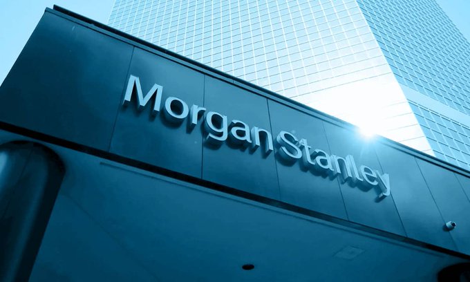 A low-angle shot displays the "Morgan Stanley" name on a building overhang, with sunlight reflecting off the glass skyscraper above. The image accompanies news of Morgan Stanley's expanding institutional exposure to XRP ETFs through its latest 13F filing.