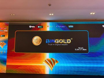 A large digital display screen at what appears to be an event venue showcases the BIGOD GOLD branding with the tagline "Trust in Digital Wealth," along with product details showing "1oz t" and dimensions "5cm x 1.5cm." The setup corresponds to the post promoting BIGOD's Booth #8 at the Vietnam RWA Summit 2026, featuring the company's promotional signage to attract attendees and encourage engagement for a chance to win BIGOD rewards.