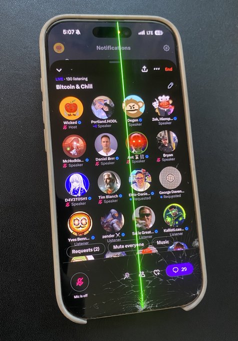 A smartphone displaying a cracked screen with a bright green vertical line running down the center, showing what appears to be a Twitter Space or Clubhouse audio room titled "Bitcoin & Chill" with multiple speaker avatars.