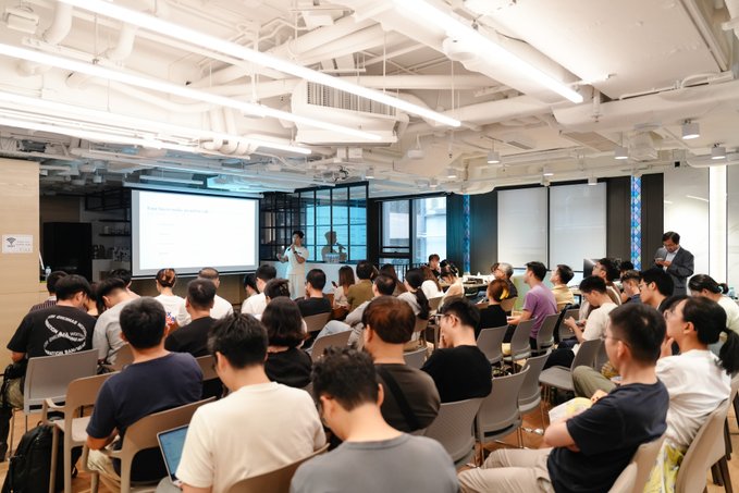 A packed tech meetup in Hong Kong hosted by Avalanche and GoKiteAI, where a speaker presents "Building AI Native Infrastructure: The Agentic Execution" to an engaged audience focused on advancing payment and agentic systems for AI.