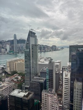 A cloudy skyline view of Hong Kong's dense skyscrapers along Victoria Harbour is shown, but the post about the Binance Book Club discussing "Binance Life" and "Poor Charlie's Almanack" doesn't appear to be related to the image at all.
