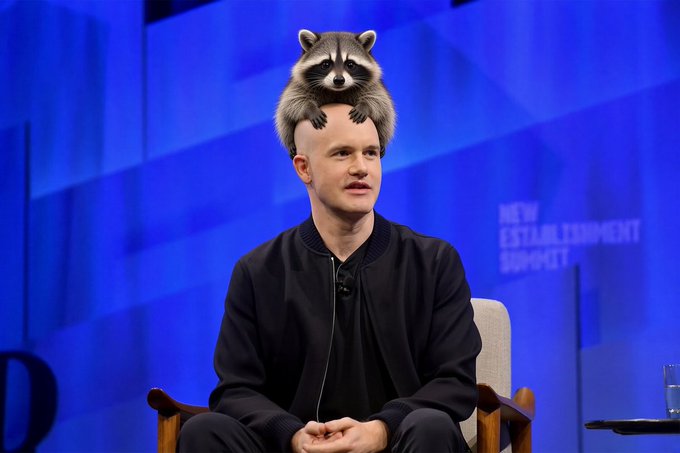 A man in a black bomber jacket sits on stage at what appears to be the New Establishment Summit, with a raccoon digitally placed on top of his head. The "coonbase" caption plays on the visual joke, referencing the man's raccoon "ears" and likely alluding to Coinbase, the cryptocurrency exchange.