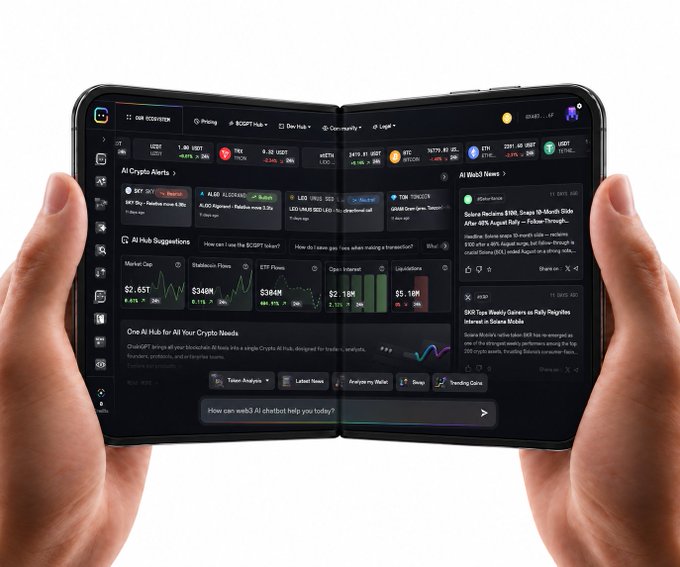 Two hands hold a foldable device displaying a crypto AI hub dashboard featuring ticker prices for BTC, ALGO, LDO, TON, ETH, and LTC, alongside AI Hub Suggestions, stablecoin charts, and AI-graded news from sources like Reuters, with a chat prompt reading "How can web3 AI chatbot help you today?"—matching the post's tagline about having the crypto AI hub in the palm of your hands.