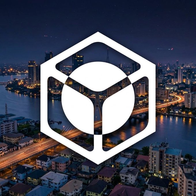 A white hexagonal logo overlay on an aerial nighttime view of a coastal city with lit-up bridges and buildings.