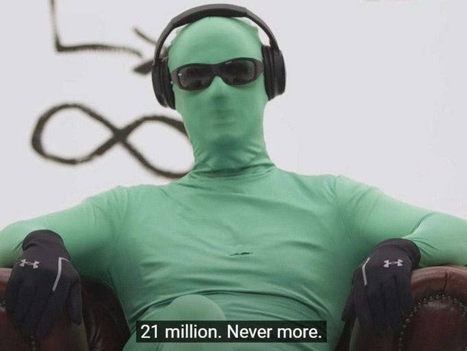 A person in a full green bodysuit, sunglasses, and headphones sits casually in a leather chair with a stern posture, accompanied by the caption "21 million. Never more."—aligning with the post's "/21M For ever," referring to Bitcoin's fixed maximum supply of 21 million coins.