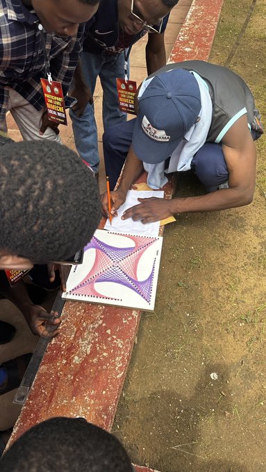 A man wearing a cap signs a poster at an outdoor event, with attendees wearing red lanyards labeled "HALALCLUB" watching closely, linking the branding to the gathering.